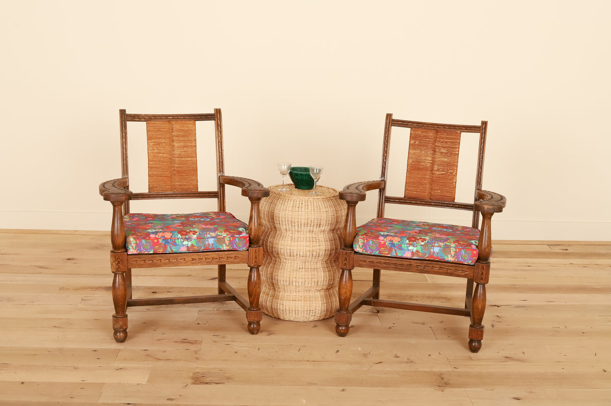 Pair of French Basque armchairs with rush backs in Kristy Stafford Textiles, front view on a wood floor