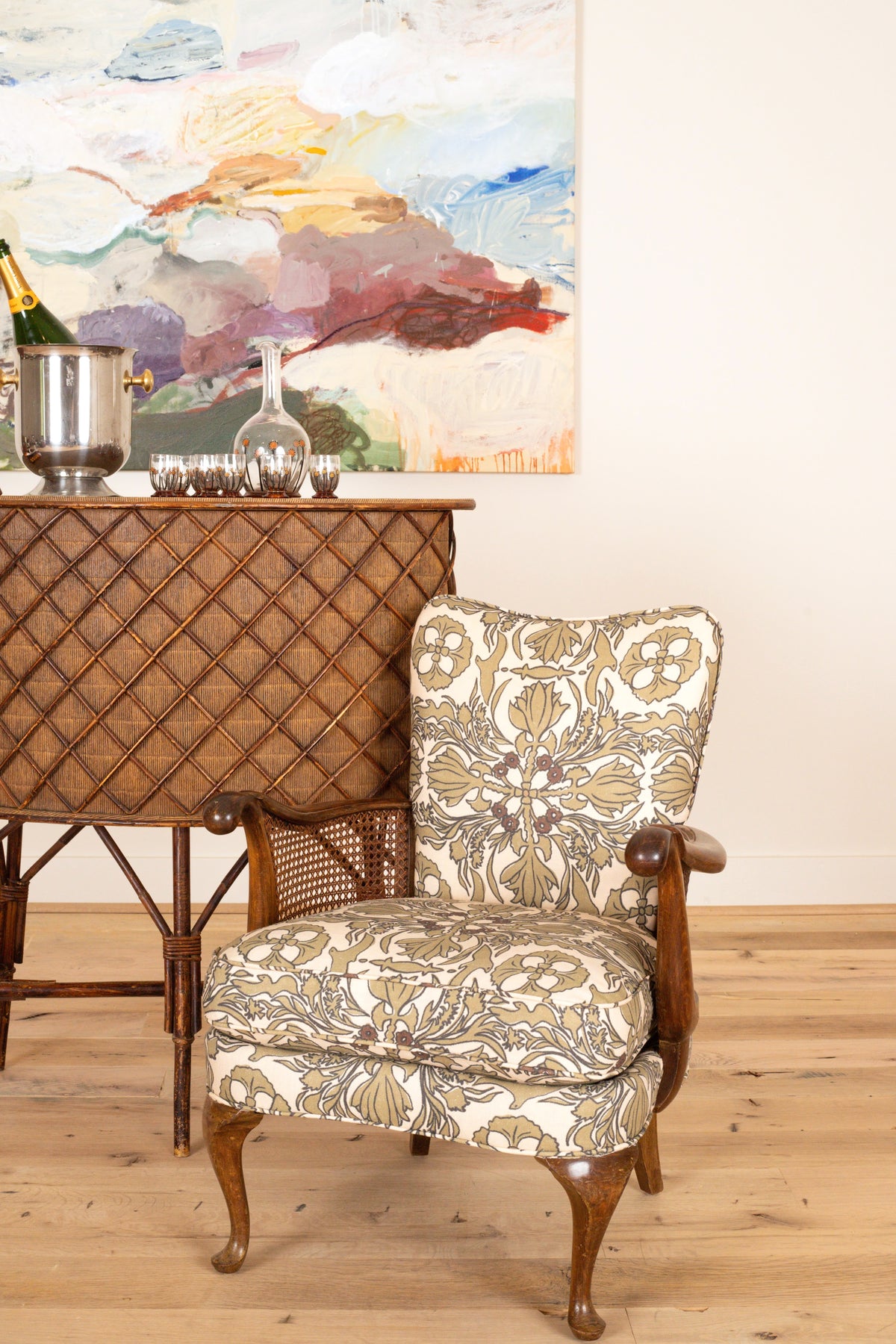 French sculptural armchair with caned sides and carved cabriole legs, three-quarter view